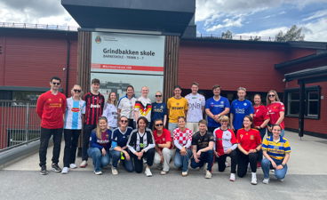 en gruppe mennesker som poserer for et bilde foran en bygning