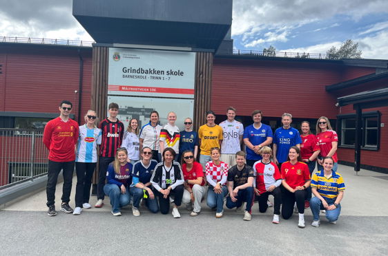 en gruppe mennesker som poserer for et bilde foran en bygning
