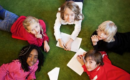 Foto: NTB scanpix Credit: Oslo kommune Barn ligger på gulvet og tegner.