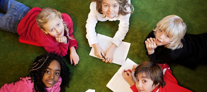 Foto: NTB scanpix Credit: Oslo kommune Barn ligger på gulvet og tegner.