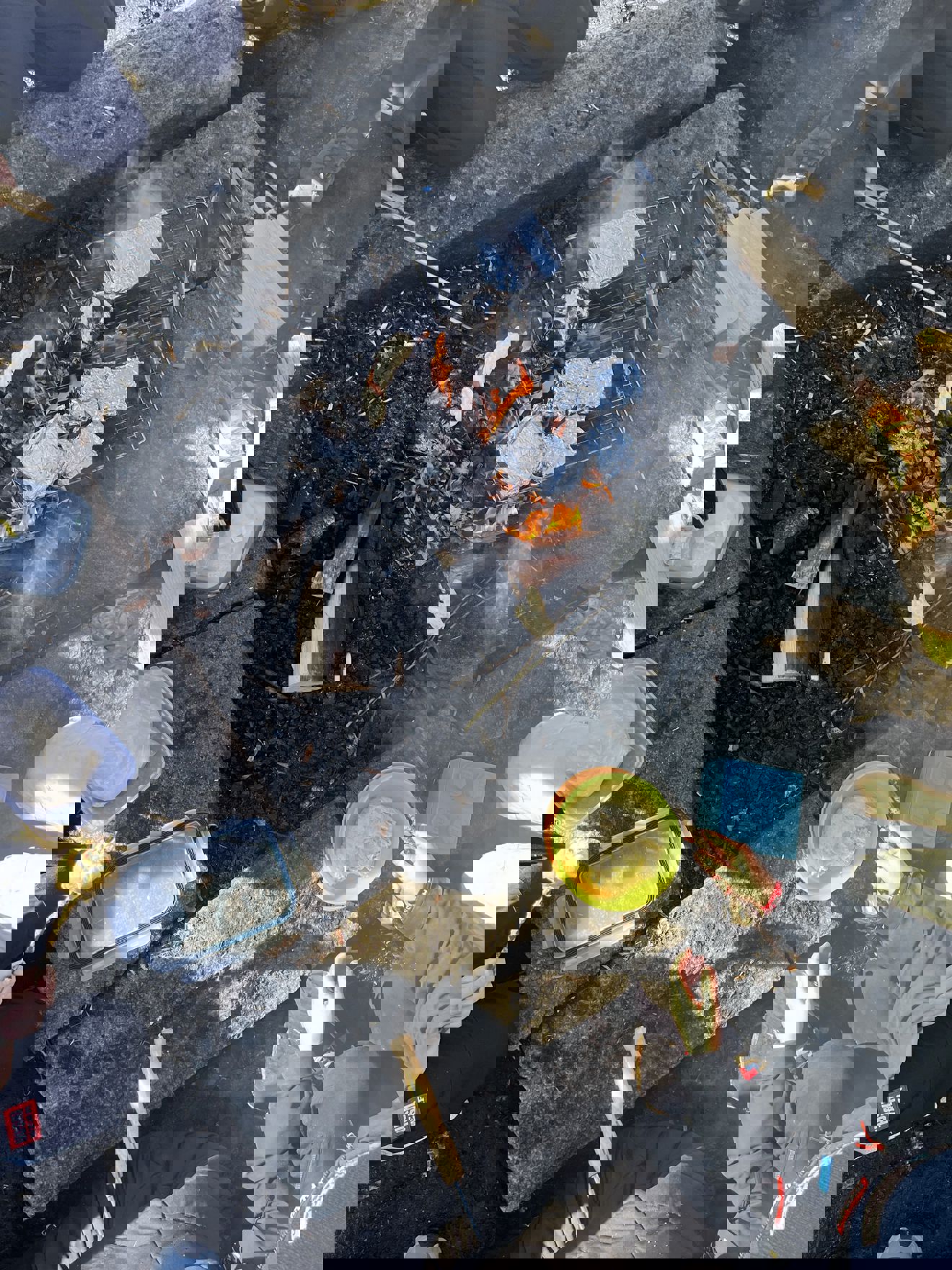 Foto: Marit Birgitte Heffermehl En person som sitter på bakken med en bøtte væske og et bål